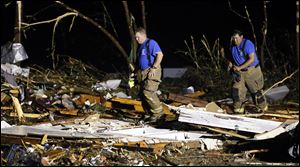 Emergency personnel search the remains of several mobile homes for survivors in Louisville, Miss., early today after a tornado hit the east Mississippi community Monday. 