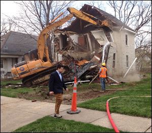 Bill Pulte Jr. walks in front of a Pontiac house being demolished by Pulte's nonprofit Detroit Blight Authority.