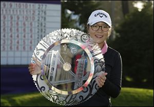Lydia Ko of New Zealand poses with her trophy on the 18th green of the Lake Merced Golf Club after winning the Swinging Skirts LPGA Classic golf tournament earlier in April.