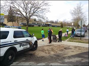 Parents and children wait outside McGregor Elementary School while Toledo  police investigate a 'suspicious package.'