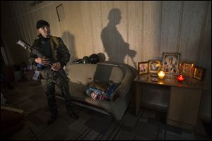 A pro-Russian gunman in camouflage uniform stands guard next to Orthodox icons today inside the Regional Prosecutor's Office building they seized on Tuesday in Luhansk, one of the largest cities in eastern, Ukraine.
