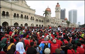 Protesters sit in front of the historical building of Sultan Abdul Samad during a protest against the implementation of the Goods and Services Tax in Kuala Lumpur, Malaysia today.