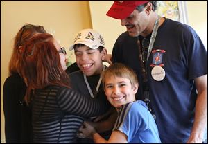 Michael Mains, 12, center left, joins in a group hug with his parents, Lisa and Michael, sister Mary, 13, and brother Christopher, 9. The family recently returned from a trip to Disney World. Michael is battling neurofibromatosis, a genetic condition characterized by a high instance of tumors.