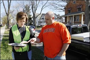Amy Tingley of Oregon speaks to Jason Ribby, East Toledo homeowner. Ms. Tingley is one of the first volunteers assisting with the Toledo Survey.