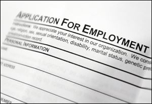 Aan employment application form sits on a table during a job fair at Columbia-Greene Community College in Hudson, N.Y. 