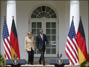 President Barack Obama and German Chancellor Angela Merkel arrive for their joint news conference in the Rose Garden of the White House in Washington.