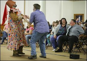 Mudge, played by Rob Grippa, left, and Henry, played by Ben Simpson, act out a scene as Tommy Stone and his mother, Ginnene, at right, laugh during a performance by Theatreworks USA, a nonprofit theater group from New York City, at the Autism Academy of Learning on Friday.