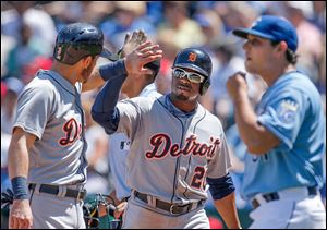Detroit’s Ian Kinsler, left, and Rajai Davis celebrate after scoring on a double by Miguel Cabrera in the fourth inning Sunday against Kansas City. The Tigers pounded out 16 hits.