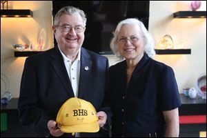 John MacDonald, left, stands with his wife Patricia, holding his Burnham High School hat.