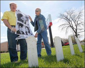 Terry Lodge of Holland, left, and Steve Miller of Toledo, hold a poster with photographs of the four Kent State undergraduates who were killed by Ohio National Guardsmen on May 4, 1970.     Friends of the Northwest Ohio Peace Coalition gathered Sunday on the 44th anniversary of the shootings.