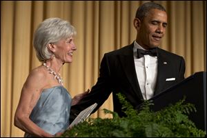 President Barack Obama, right, has outgoing Health and Human Services Secretary Kathleen Sebelius come on stage as part of a joke to fix a technical glitch at the end of his speech.