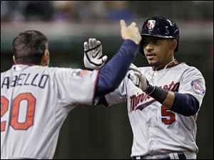 Minnesota Twins' Eduardo Escobar (5) celebrates his solo home run off Cleveland Indians relief pitcher John Axford with Chris Colabello (20) in the 10th inning.