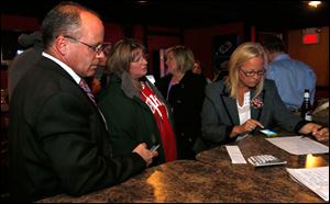 Bedford Schools superintendent Mark Kleinhans, Sandy Kraine, and board trustee Lisa McCaig tally school levy results at Sidelines in Lambertville, Mich.