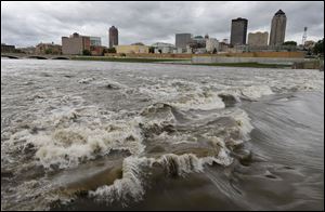 Water splashes over the Center Street Dam in the swollen Des Moines River in downtown Des Moines, Iowa, in May, 2013.