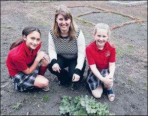 St. Pius X fifth graders Maria Richard, left, and Lauren Hitts with teacher Jen Ohms. 