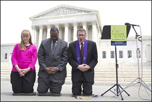 Rev. Rob Schenck, of Faith and Action, right, prays in front of the Supreme Court with Raymond Moore, and Patty Bills, both also of Faith and Action.