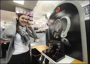 A customer tests out the sounds of Beats by Dr. Dre headphones at a Staples store in New York City