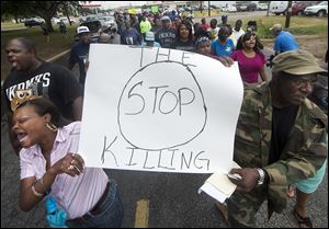 K.K. Davis, left, and Tommy Jones of Hearne carry a sign with other protesters outside the Hearne, Texas police department.
