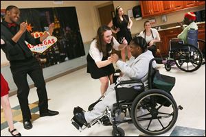 Nonso Agubosim, left, watches Ashley Wolfenbarger, center, dance with Stacye Griffin at The Laurels during a prom sponsored by the organizaton Adopt-A-Grandparent.