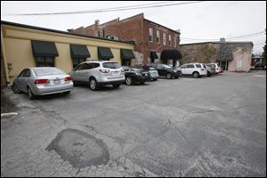 Cars are parked behind Chandler Cafe on Main Street in Sylvania. Consolidating parking lots in the area could cost at least $800,000.