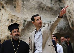 Syrian President Bashar Assad, right, visits the Christian village of Maaloula, near Damascus, Syria. 