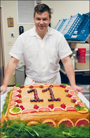 Chef Sam with Louie the elephant’s birthday cake of polenta and peanut butter icing and decorated with fruit.