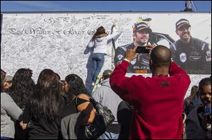 Fans crowd the scene of a memorial rally and car cruise in Valencia, Calif., to remember actor Paul Walker and his friend Roger Rodas, who died in a fiery car crash in this 2013 file photo.