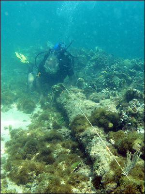 In this May 2003 photo, a diver measures a lombard cannon adjacent to a ballast pile, off the North coast of Haiti, at a site explorer Barry Clifford says could be the wreckage of Cristpher Colombus' flagship vessel the Santa Maria. 