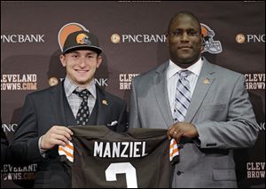 Cleveland Browns quarterback Johnny Manziel, from Texas A&M, holds his new jersey with general manager Ray Farmer at the NFL football team's facility in Berea, Ohio.
