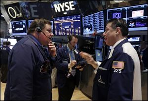 Traders John Santiago, left, and William McInerney, right, work on the floor of the New York Stock Exchange.