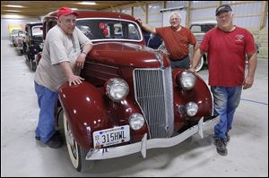 From left, Emery Ward III, John Ward, and Jeff Ward prepare to sell off their father’s 1936 Ford cars at an auction in Sandusky on Saturday.