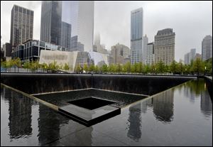 A view of the National September 11 Memorial Museum with the north reflecting pool in foreground during the museum's dedication ceremony.