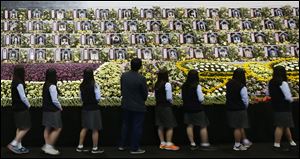 Middle school students view portraits of the victims of the sunken ferry Sewol at a group memorial altar in Ansan, South Korea, today.