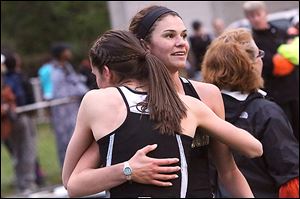 Perrysburg’s Courtney Clody gets a hug after winning the 1600 in a meet-record 5:04.09. She also won the 800.
