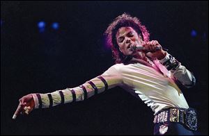 Michael Jackson leans, points and sings, dances and struts during the opening performance of his 13-city U.S. tour in this 1988 file photo