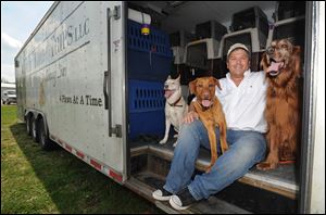 Greg Mahle poses with his dogs Murphy, Beans and Treasure, in the Rescue Road Trips trailer. Mahle drives more than 40,000 miles a year rescuing dogs from shelters and pounds in the south. Each trip can save 80 dogs from being put down.