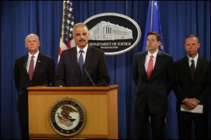 Attorney General Eric Holder, accompanied by, from left, U.S. Attorney for Western District of Pennsylvania David Hickton,  Assistant Attorney General for National Security John Carlin, and FBI Executive Associate Director Robert Anderson, speaks at a news conference at the Justice Department in Washington, today.
