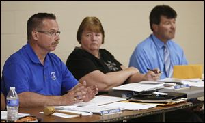 President John Livingston, left, briefly talks about the ongoing investigation during the board meeting. Center is board treasurer Jodie Ribley, and Superintendent Eric Hoffman is at right.