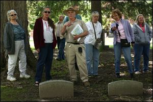 Architect Rob Lamlein, center left, explains a sarcophagus during a walk through Historic Woodlawn Cemetery on Sunday in West Toledo. The cemetery has 77,000 people interred on its grounds.