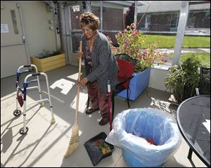 Mamie Alfred helps with the sweeping.