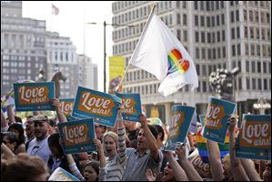 People hold up signs and cheer during a rally at City Hall, in Philadelphia.