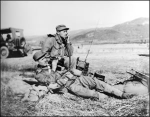  Cpl. Harold W. Reed, foreground with binoculars, is shown on the North Korean front. On the day he was killed, Chinese troops attacked in snowy, freezing weather.  Corporal Reed’s family learned of his death the day after Christmas, 1950. His flag-draped coffin is to land today in Detroit and is to be buried in the family plot his mother had long hoped would be his final resting place.
