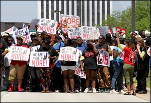 Protesters walk down Jorie Blvd. in Oak Brook, Wednesday near the McDonald’s Corp. headquarters in Oak Brook, Ill. railing about low wages and seeking $15 per hour for the rank and file. 