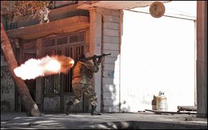 An Afghanistan's National Army (ANA) soldier fires his weapon at the site of a clash between insurgents and security forces over Indian Consulate in Herat, Afghanistan today.