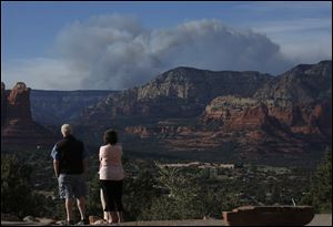 Tourists watch the Slide Fire from a scenic overlook as it burns up Oak Creek Canyon nearby on Thursday in Sedona, Ariz.