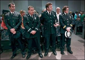 From left, Lt. Michael Howe, Capt. Robert Walters, Battalion Chief Michael Nicely, and Assistant Chief Karen Marquardt listen during the Toledo Fire Department’s promotion ceremony Friday at One Government Center.