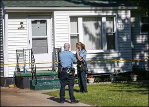 Toledo police officers Colin O'Rourke and Michelle Sterling secure the home of Thomas Przybysz, 30, of 4635 283rd St., who was killed outside of his residence. They were waiting for a search warrant.