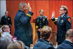 Battalion Chief Verdell Franklin swears in the Toledo Fire Department’s newly promoted Deputy Assistant Chief Karen Marquardt during a ceremony Friday at Government Center.