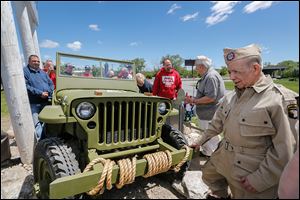 World War II veteran and Jeep retiree Lupe Flores, right, looks at the restored Jeep. Behind him is Ron Szymanski, and Bob Kiss, one of the painters on the project. 