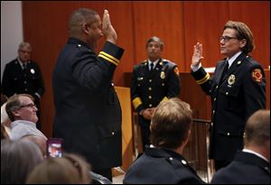 Toledo Fire and Rescue Department Battalion Chief Verdell Franklin swears in the department's newly promoted Deputy Assistant Chief Karen Marquardt during a promotion ceremony at One Government Center.